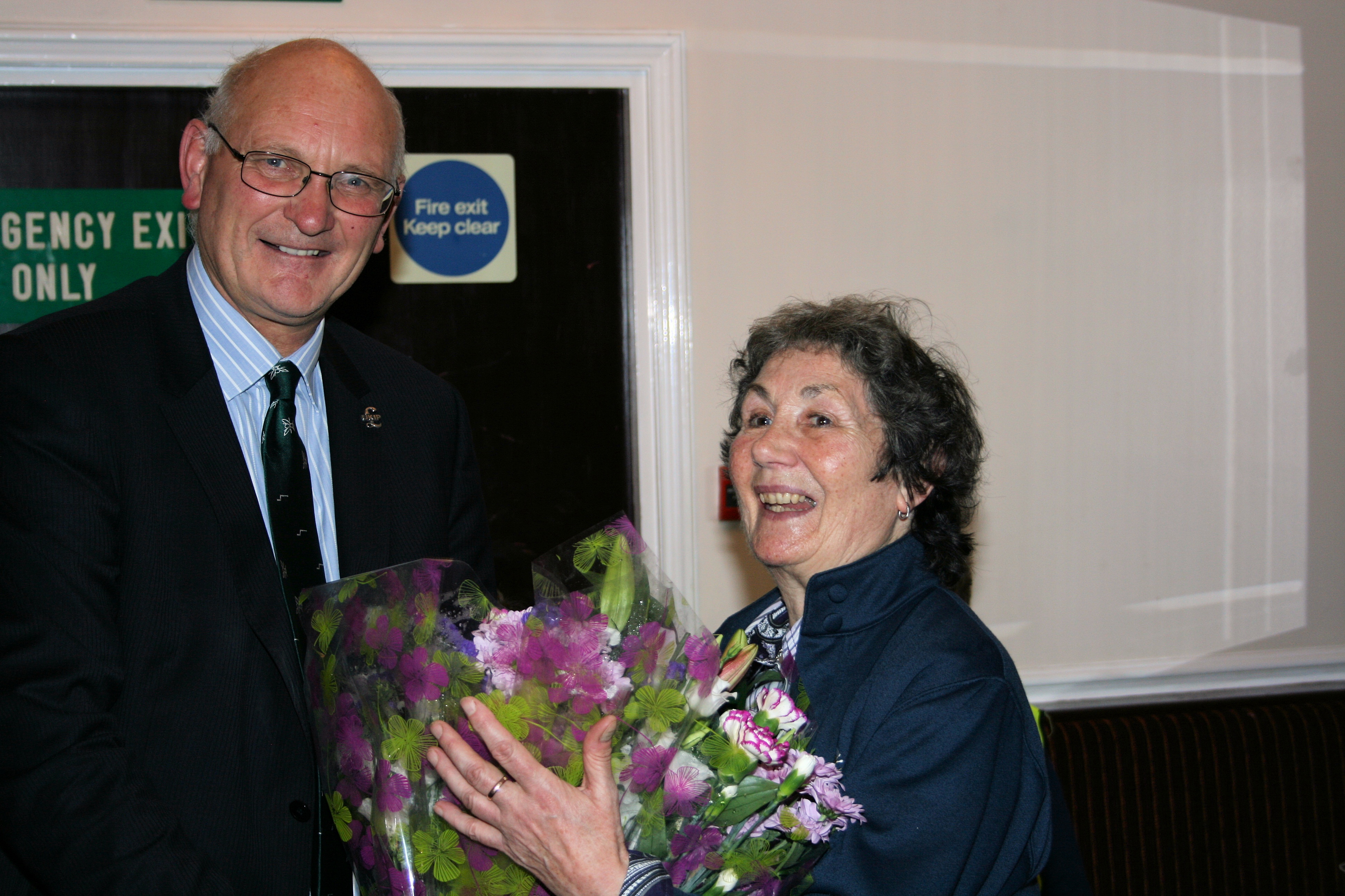 Margaret Rycroft receiving a bouquet from Stuart Agnew
